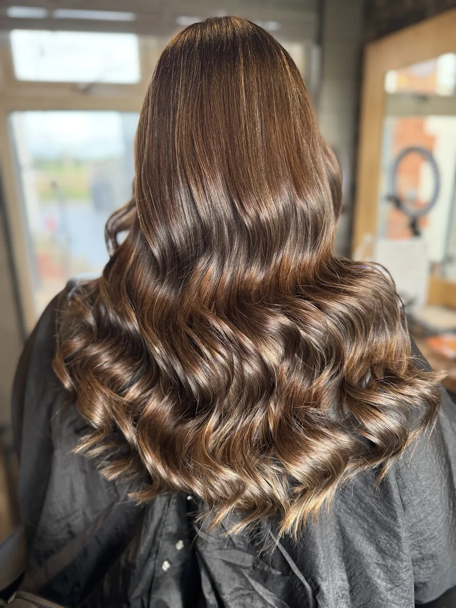 After: warm blonde ombré changed to a rich, glossy chocolate brunette with soft waves