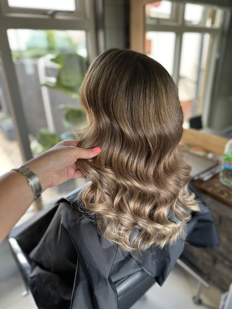 Long, glossy brunette hair styled in soft waves