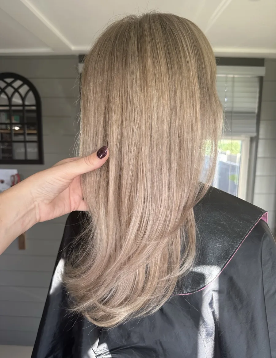 After: yellow-toned blonde refreshed to a soft beige blonde with long layers