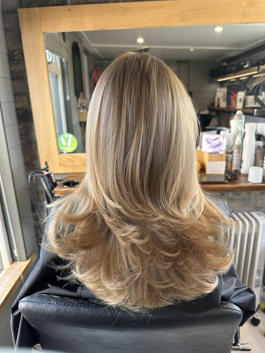 Warm honey blonde with long, bouncy layers