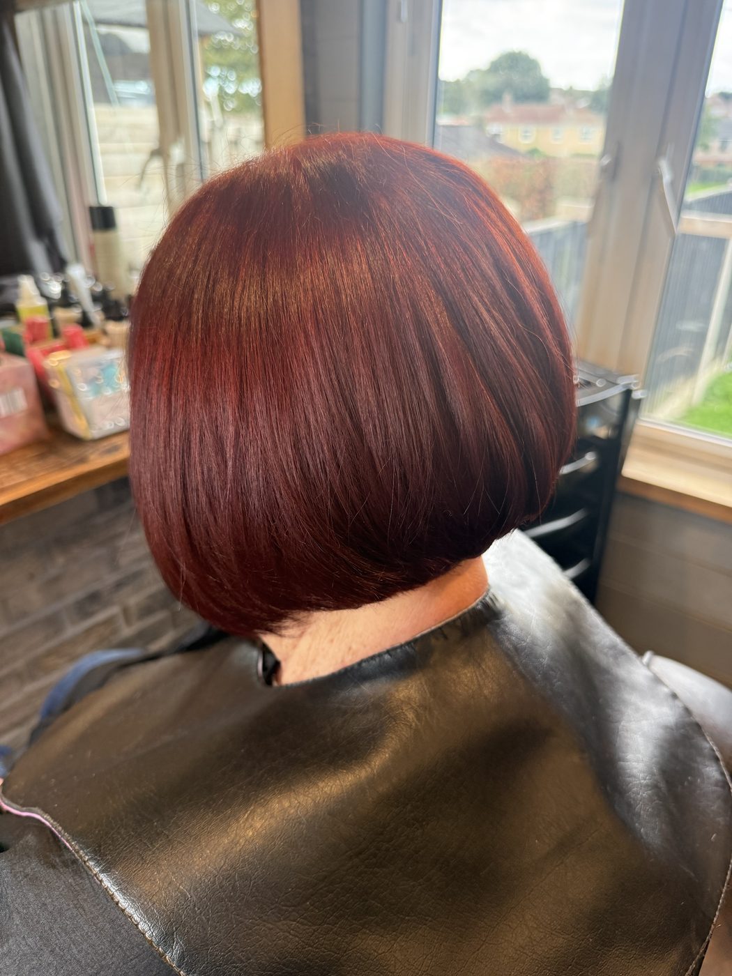 After: faded copper refreshed to a rich red, with a sharp, polished bob