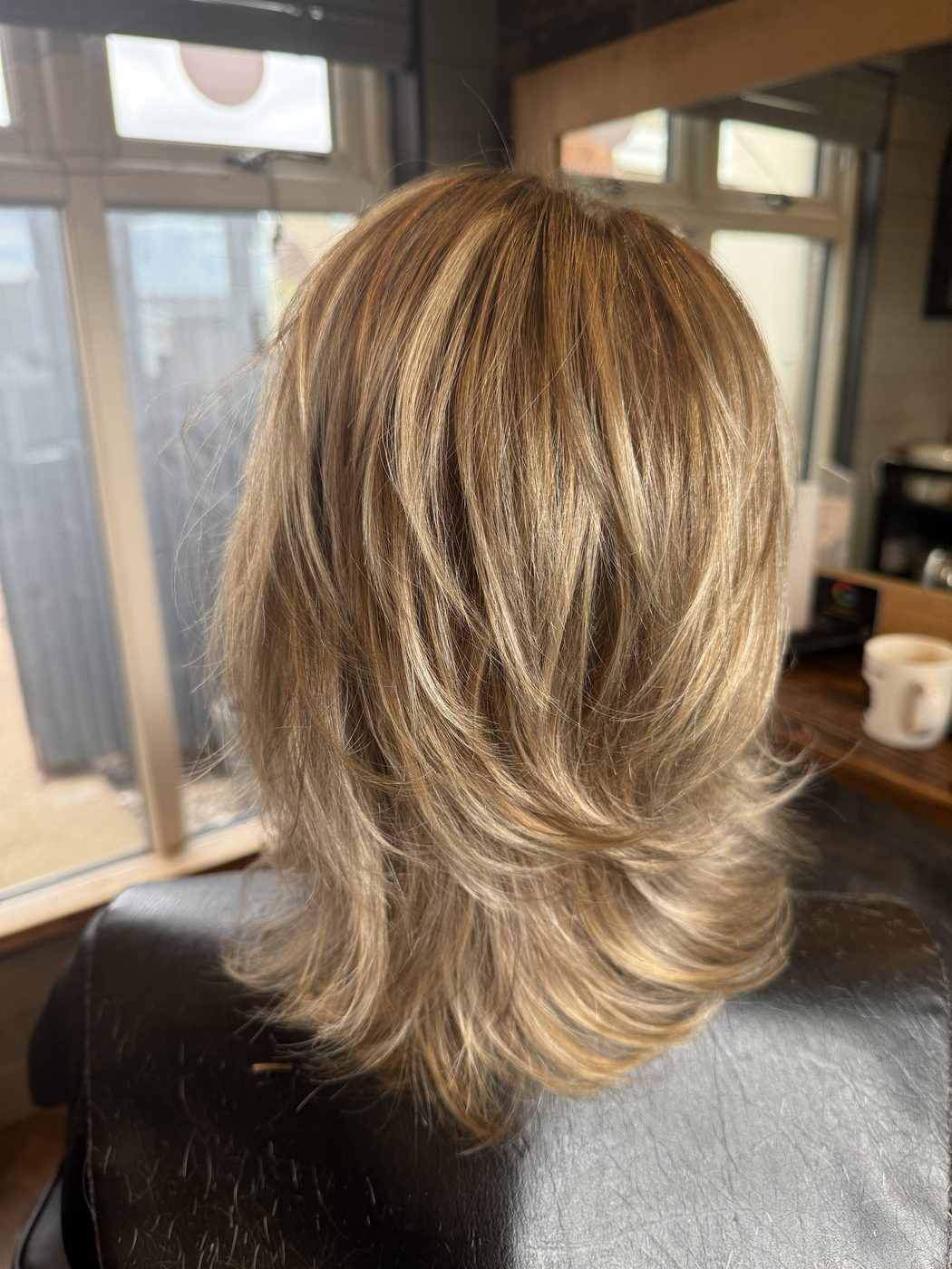After: dry, grown-out blonde lifted and cut into soft, bouncy layers