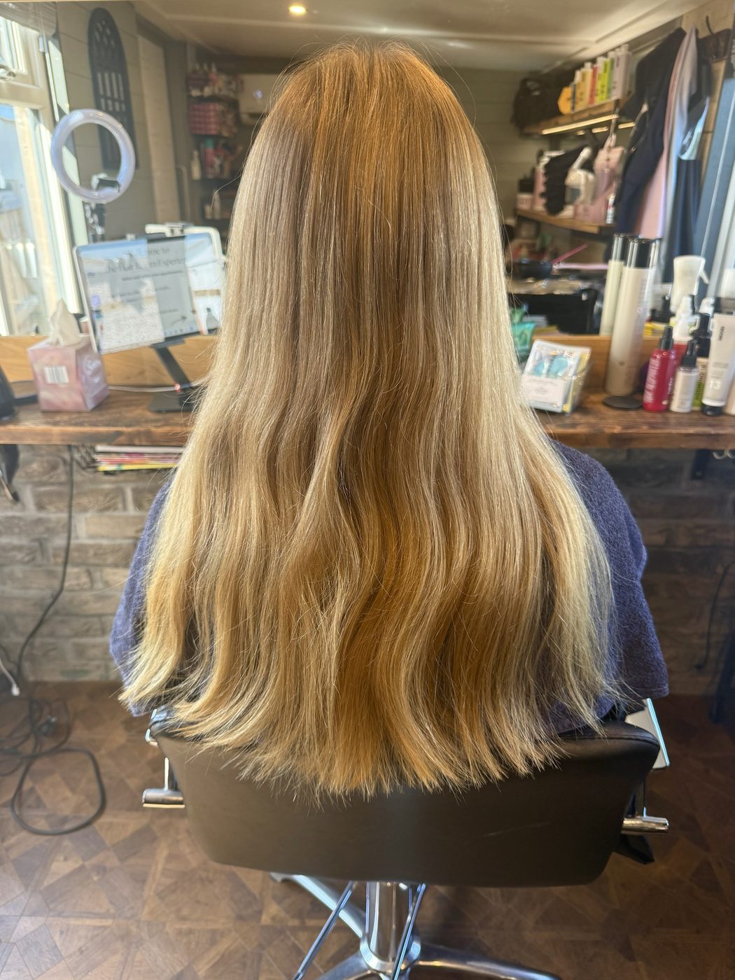 Before: flat golden lengths brightened into a soft, dimensional blonde with loose waves