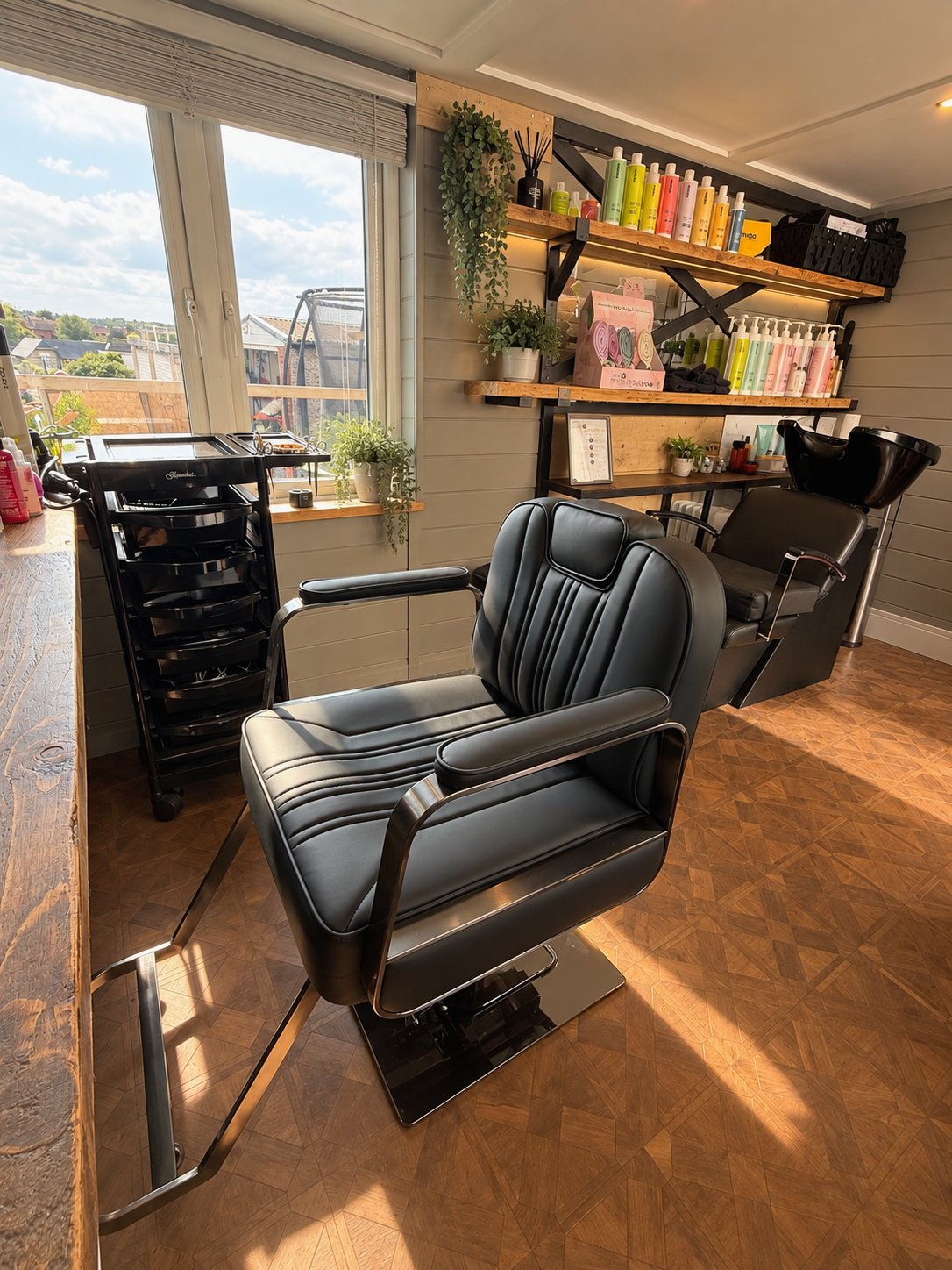 Inside The Hair Room at Harthill: a sunlit, private salon room with a styling chair, backwash and MOOD haircare shelves